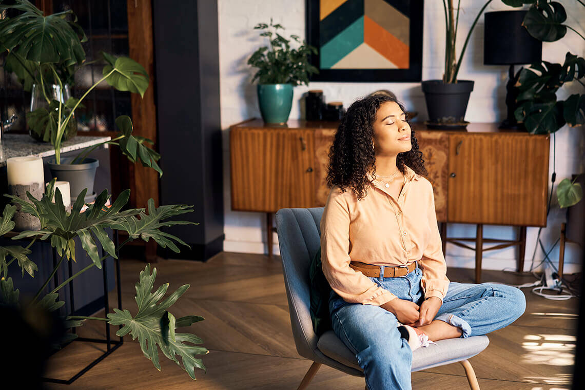 Female sitting in a chair surrounded by plants